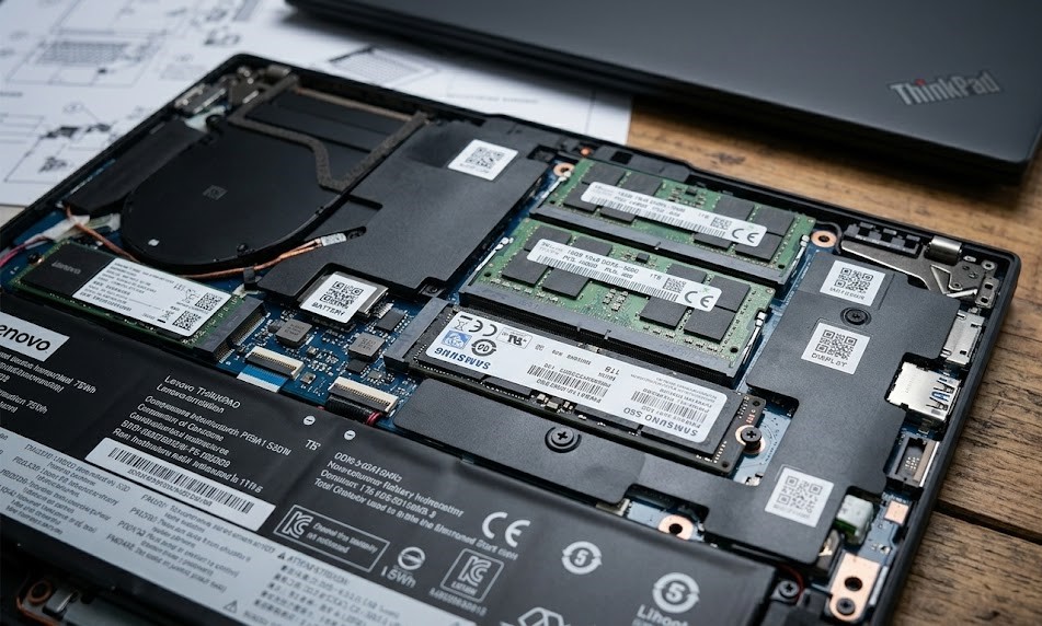 Close-up of the Lenovo ThinkPad T14 Gen 5 internal mainboard showing user-replaceable SODIMM RAM and M.2 SSD modules.